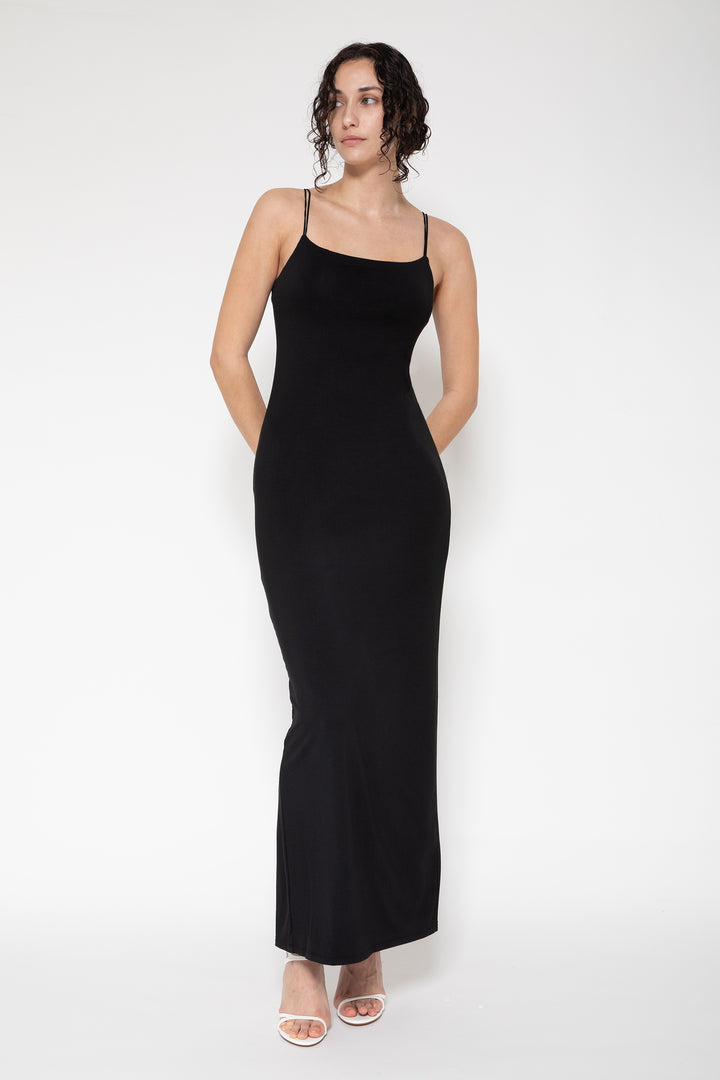 Woman modeling front of the black "Collagen Double Strap Cami Dress"