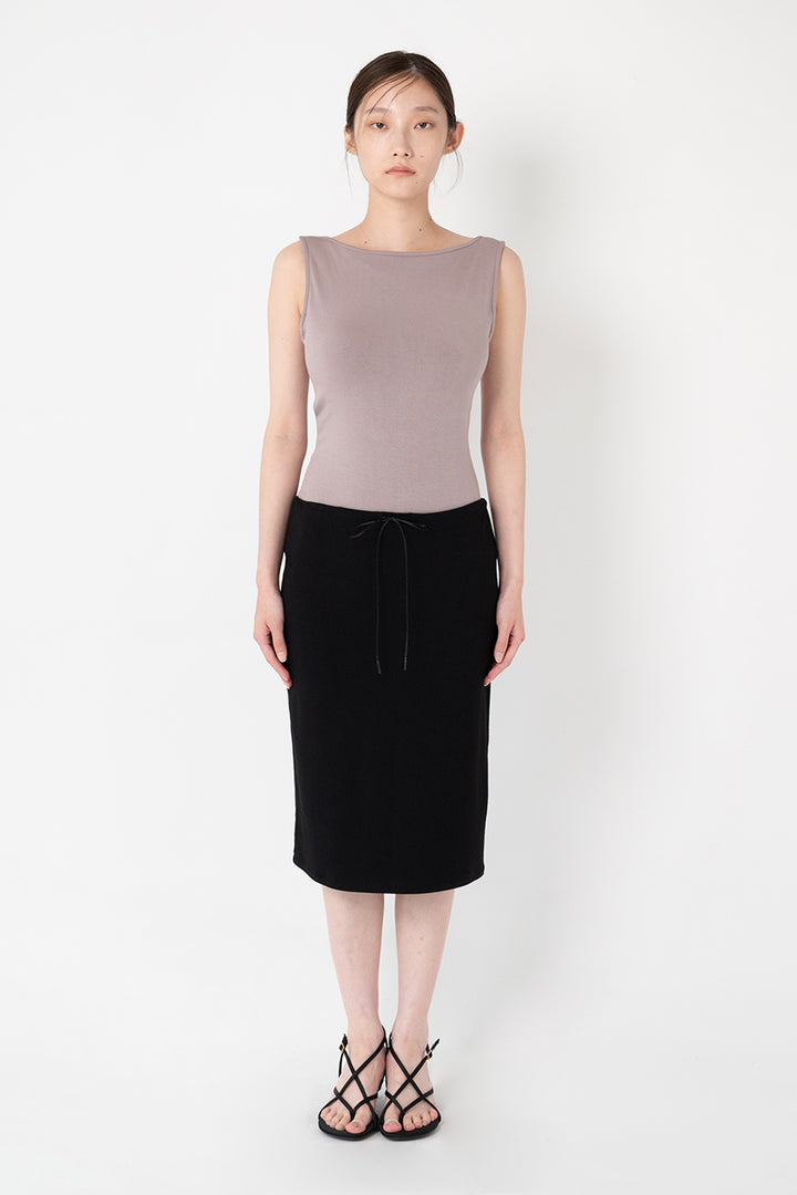 Woman modeling front of the black”Collagen Midi Skirt"