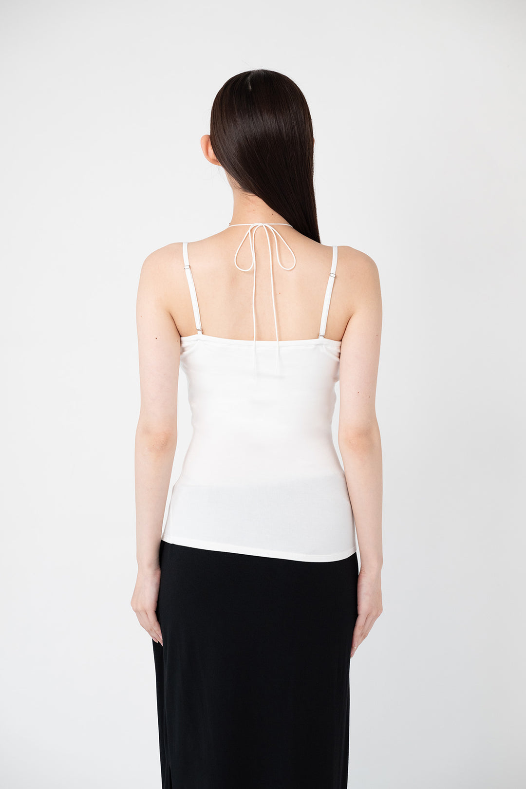 Woman modeling front of the white "Collagen Multi-way Cami "