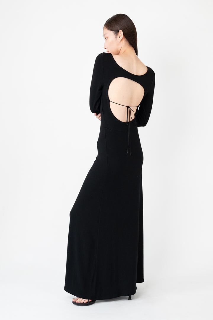 Woman modeling front of the black "Open Back Dress"