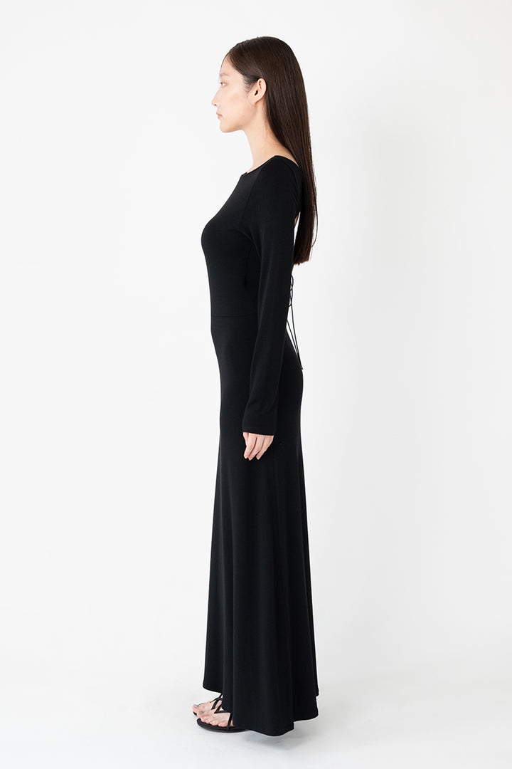 Woman modeling front of the black "Open Back Dress"