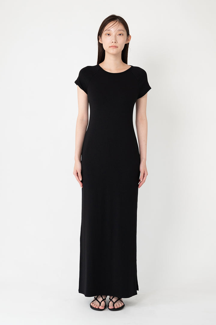 Woman modeling front of the black "Collagen Raglan Sleeve Dress "