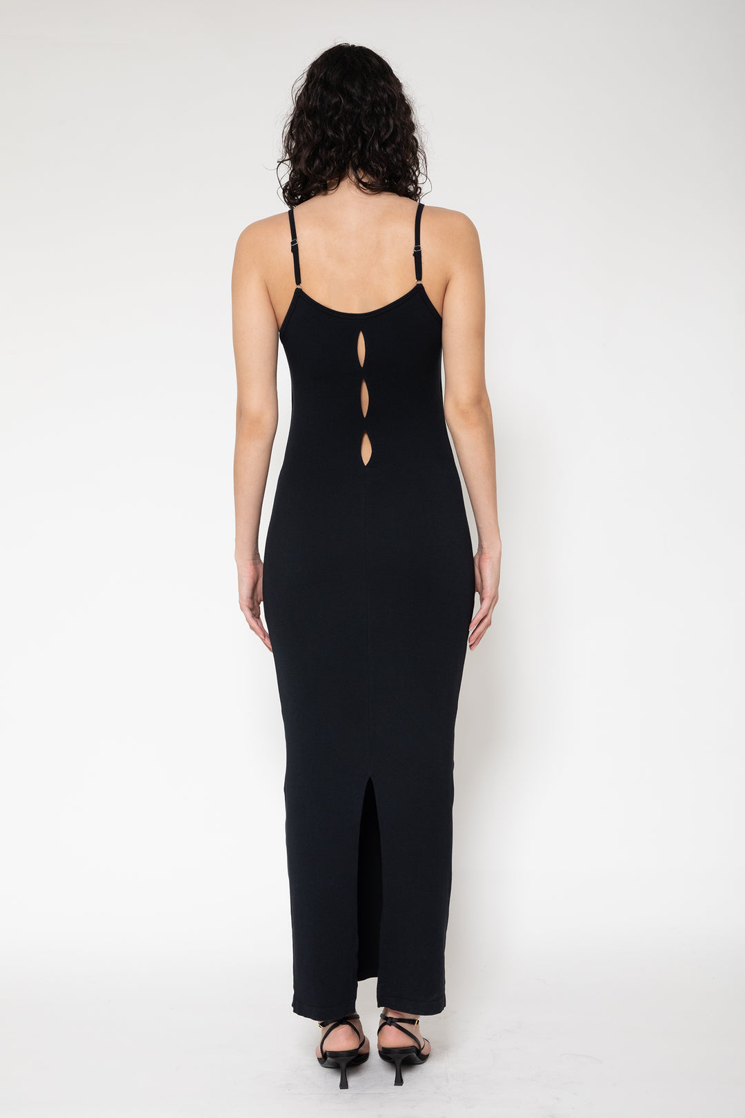 Woman modeling front of the black”Collagen Ribbed Back-slit Dress"