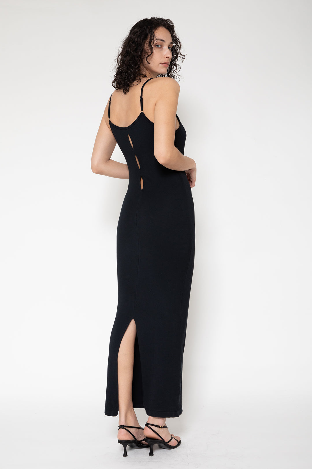 Woman modeling front of the black”Collagen Ribbed Back-slit Dress"