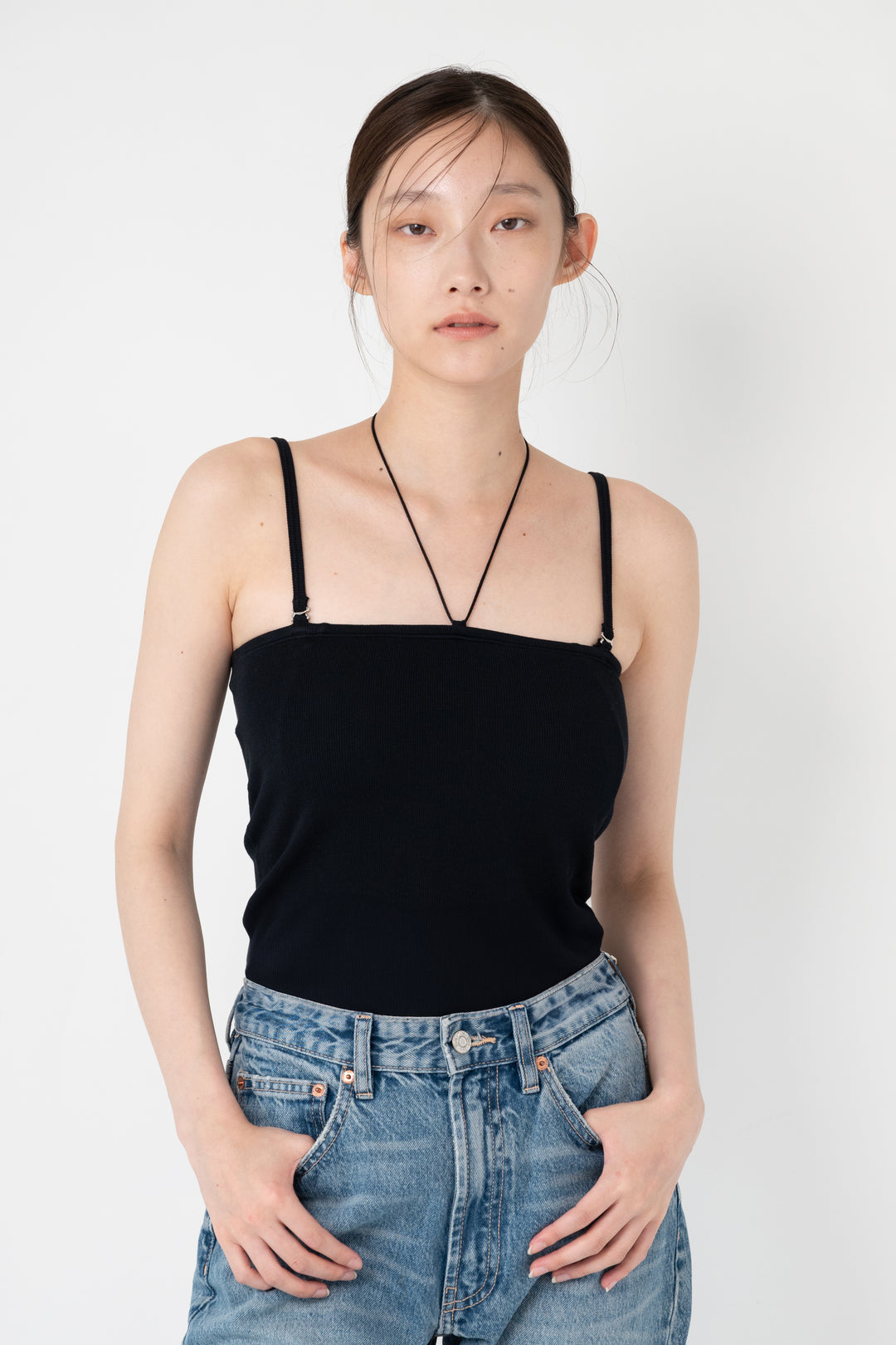 Woman modeling front of the black”Collagen Ribbed Multiway Cami"