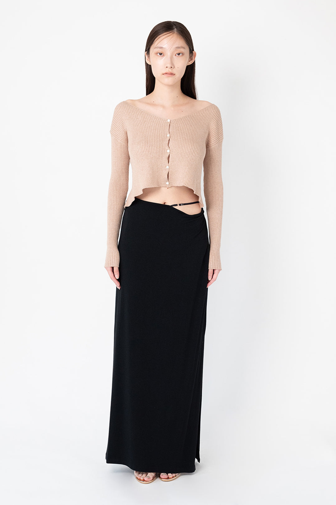 Woman modeling front of the black "Collagen Strappy Maxi Skirt”