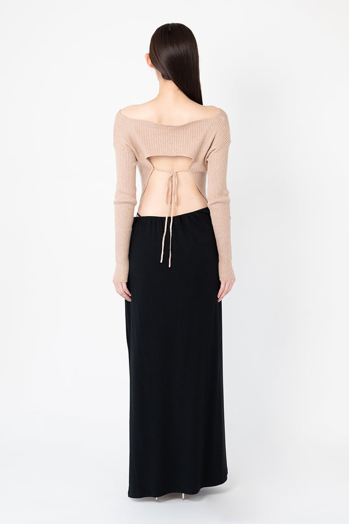 Woman modeling front of the black "Collagen Strappy Maxi Skirt”