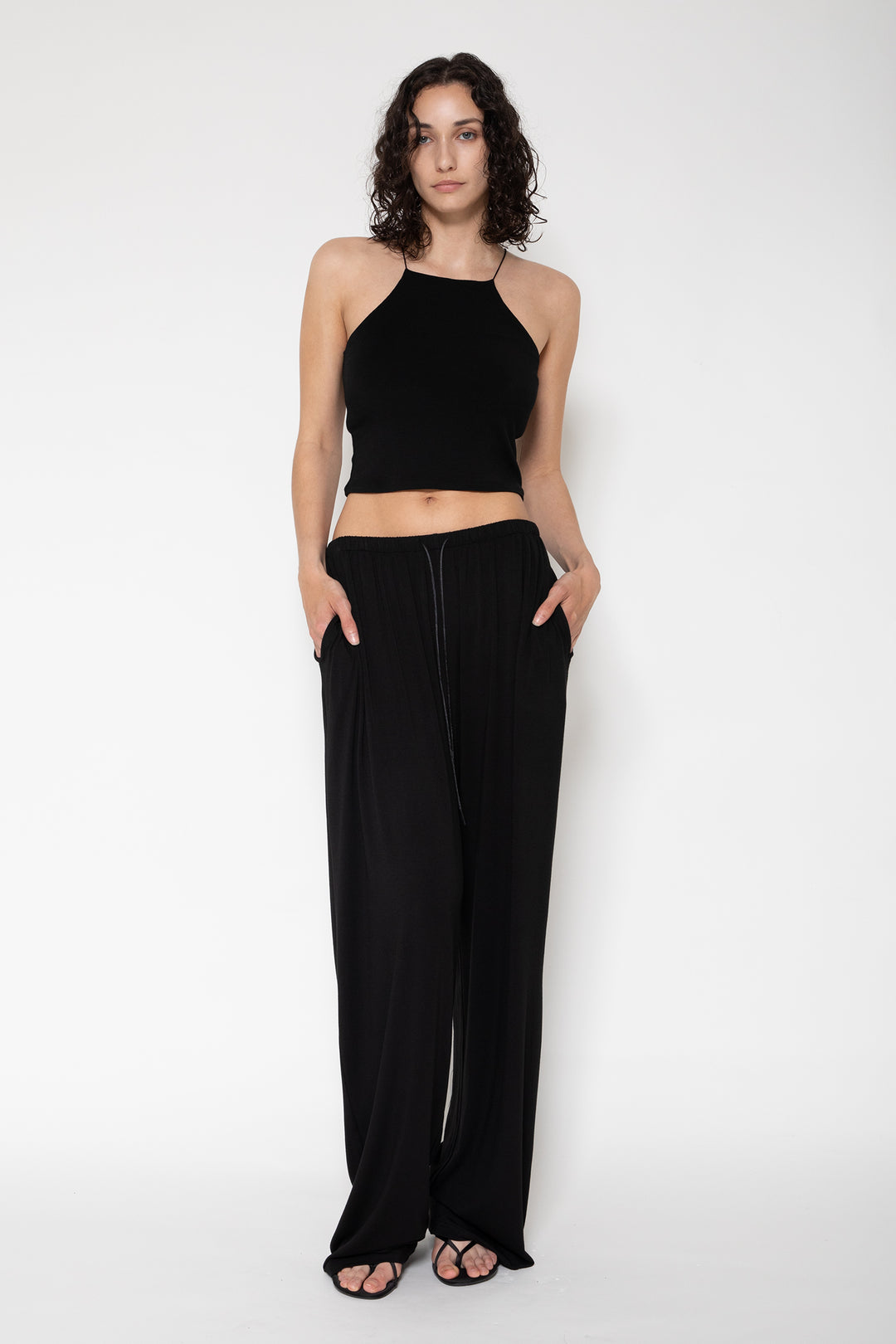 Woman modeling front of the black "Collagen Weekend Pants"