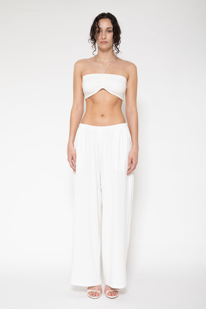 Woman modeling front of the white "Collagen Weekend Pants"