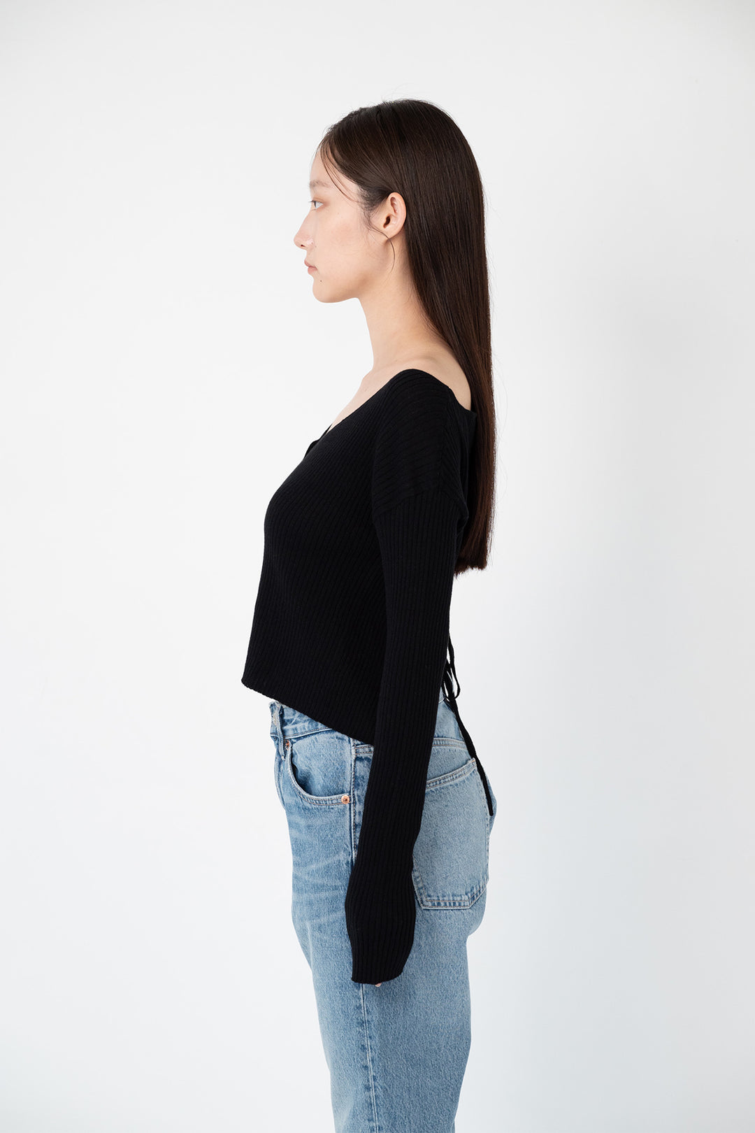 Woman modeling side of the black "back ribbon short cardigan"